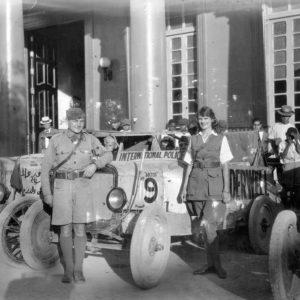 A man and a lady standing in front of a vehicle